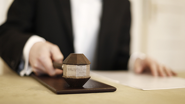 Henkilö kädessään puheenjohtajan nuija.