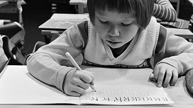 Koululais-tyttö kirjoittaa.