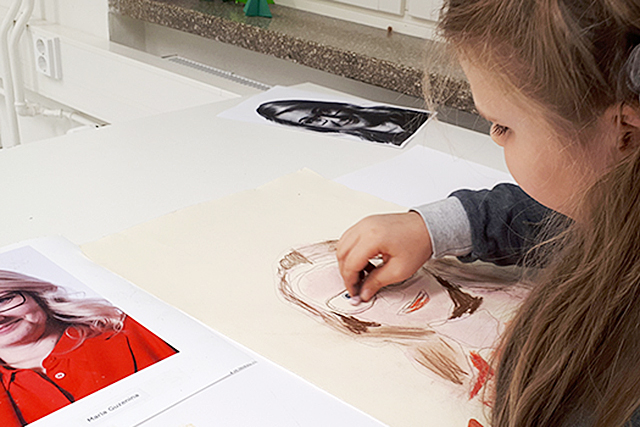 Koululainen piirtää muotokuvaa