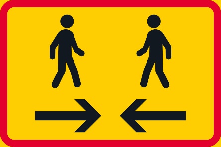 Keltaisella pohjalla, jossa punaiset reunat, kaksi kävelevää ihmishahmoa vastakkain ja niiden alapuolella kaksi nuolta vastakkain.